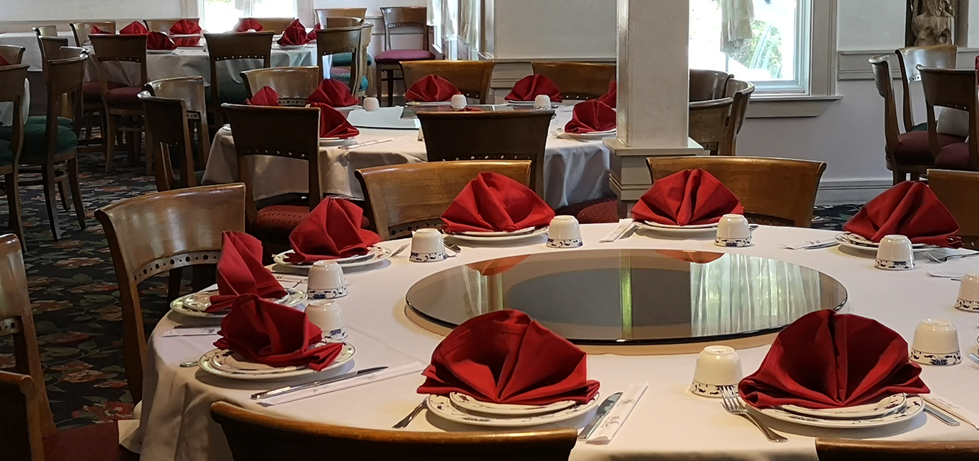 Su Chang's dining room: tables neatly set up with plates, utensils, and red napkins.